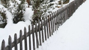 A multi-story hotel with balconies and a snow-covered fence. - Haus Granit Zermatt (Zermatt)