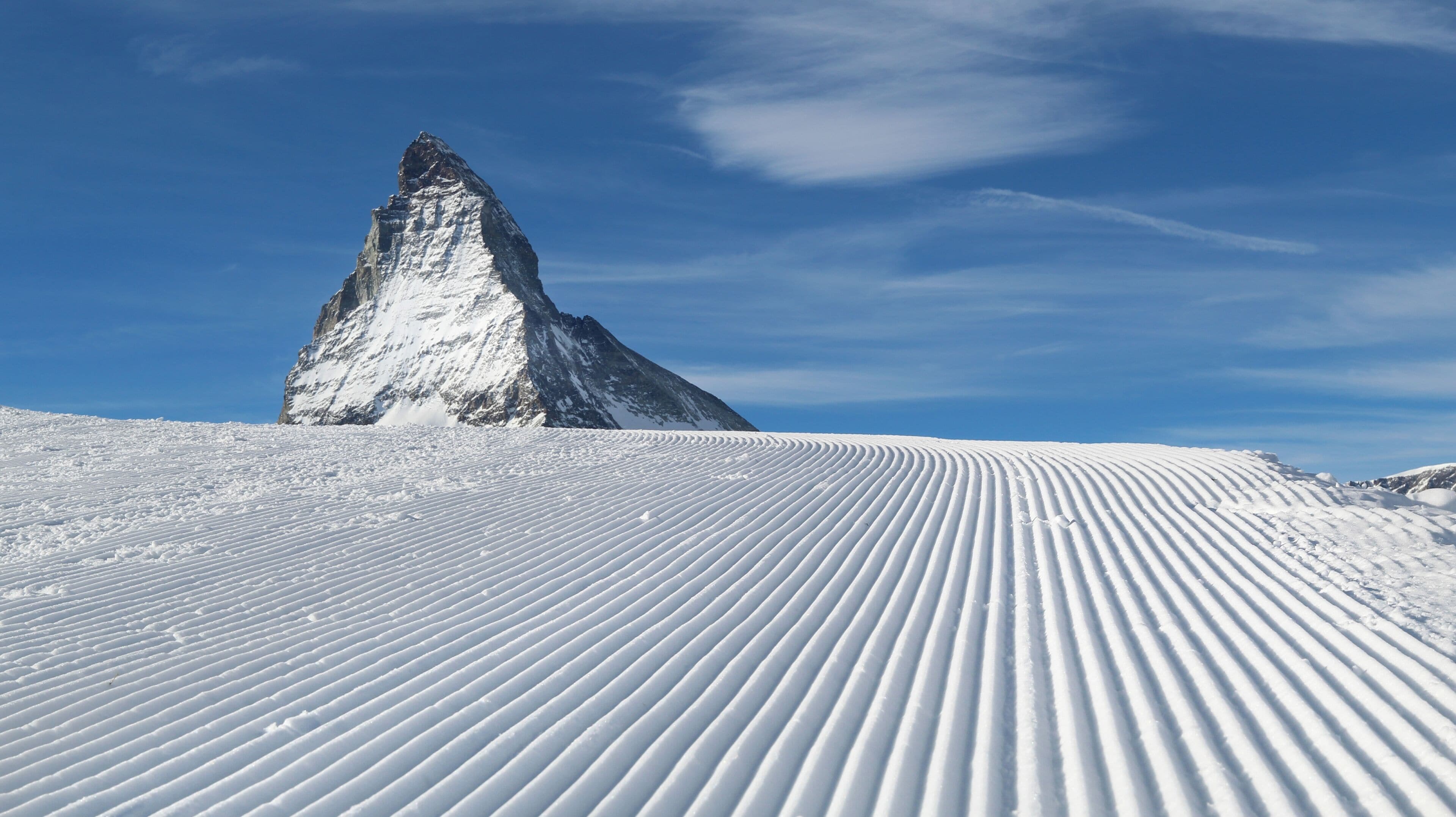 A snow-covered mountain peak with a clear sky.