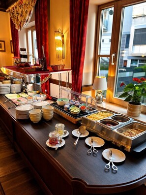 Un buffet proposant une variété de plats, d’assiettes et de couverts.