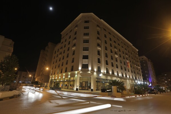 A multi-story hotel with a prominent entrance, large windows, and a well-lit facade. - Corail Suites Hotel (Tunis)