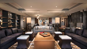 Un salon moderne avec un ensemble de canapés, une table basse et une cuisine en arrière-plan.