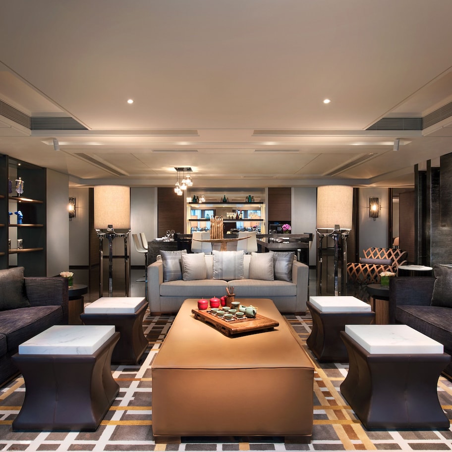 A modern living room with a sofa set, a coffee table, and a kitchen in the background.