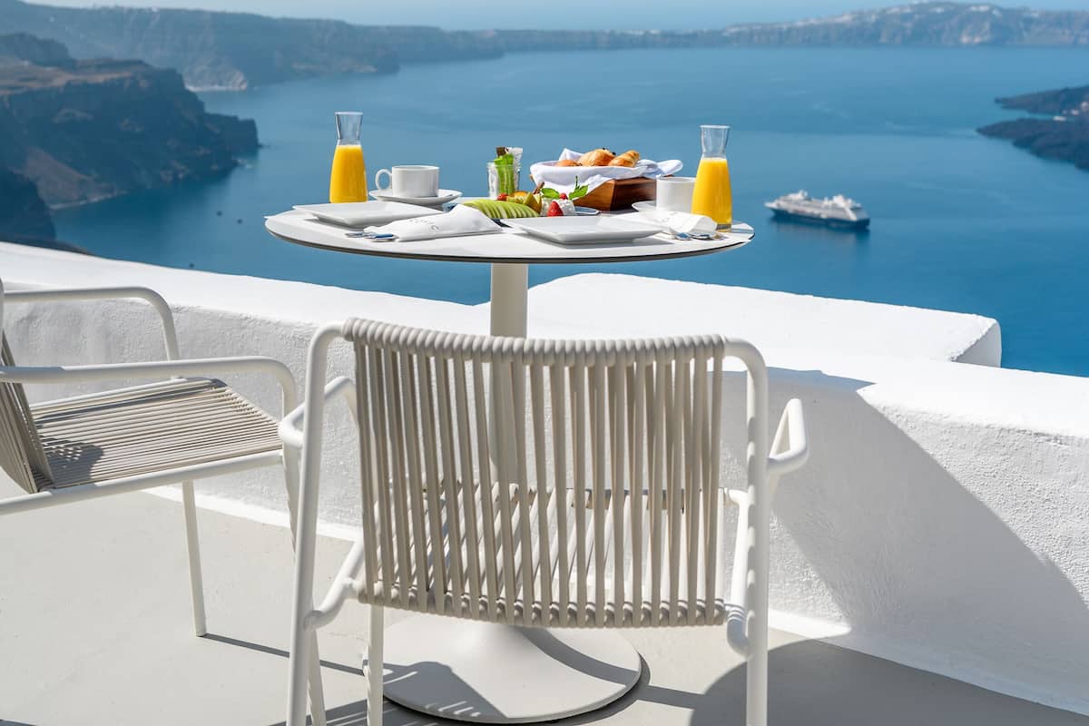 A table with breakfast items and a view of the sea.