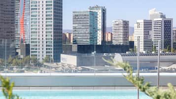 Een buitenzwembad, ligstoelen bij het zwembad