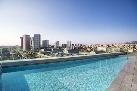 Una piscina al aire libre, sillones reclinables de piscina