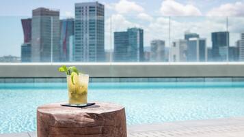 Una piscina al aire libre, sillones reclinables de piscina