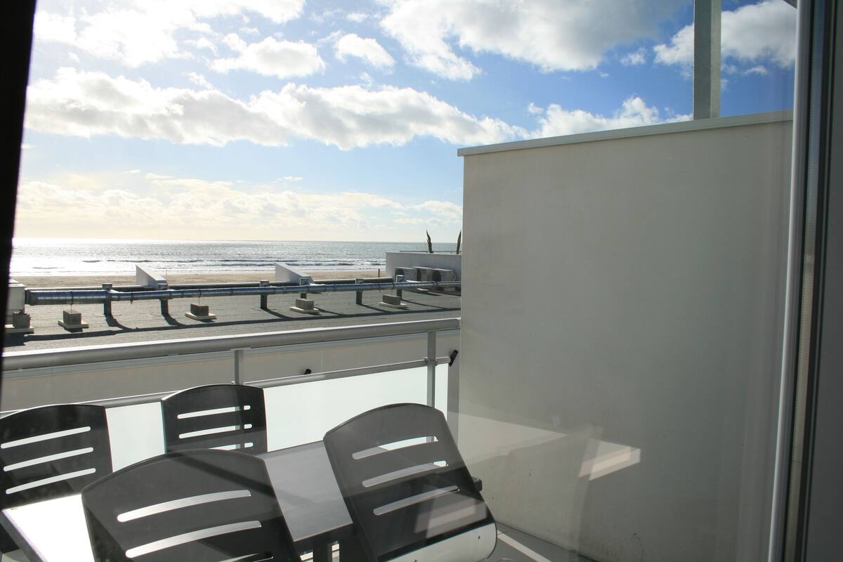 Ein Balkon mit Blick auf Strand und Meer.