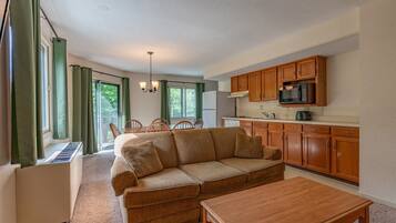 Standaard suite, 1 slaapkamer, kitchenette | Woonruimte | Een 32-inch televisie met kabelzenders en tafelvoetbal