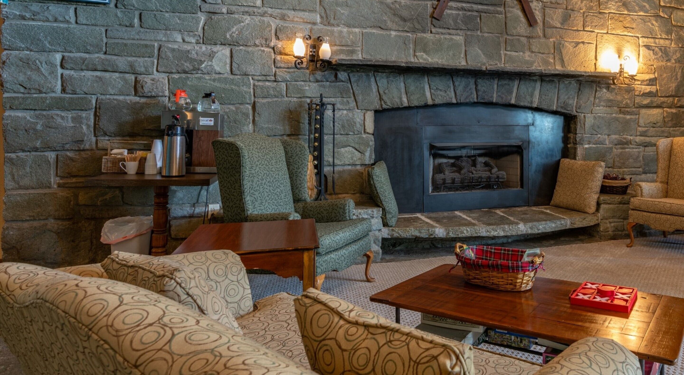 A cozy living room with a stone fireplace, comfortable seating, and a coffee table.