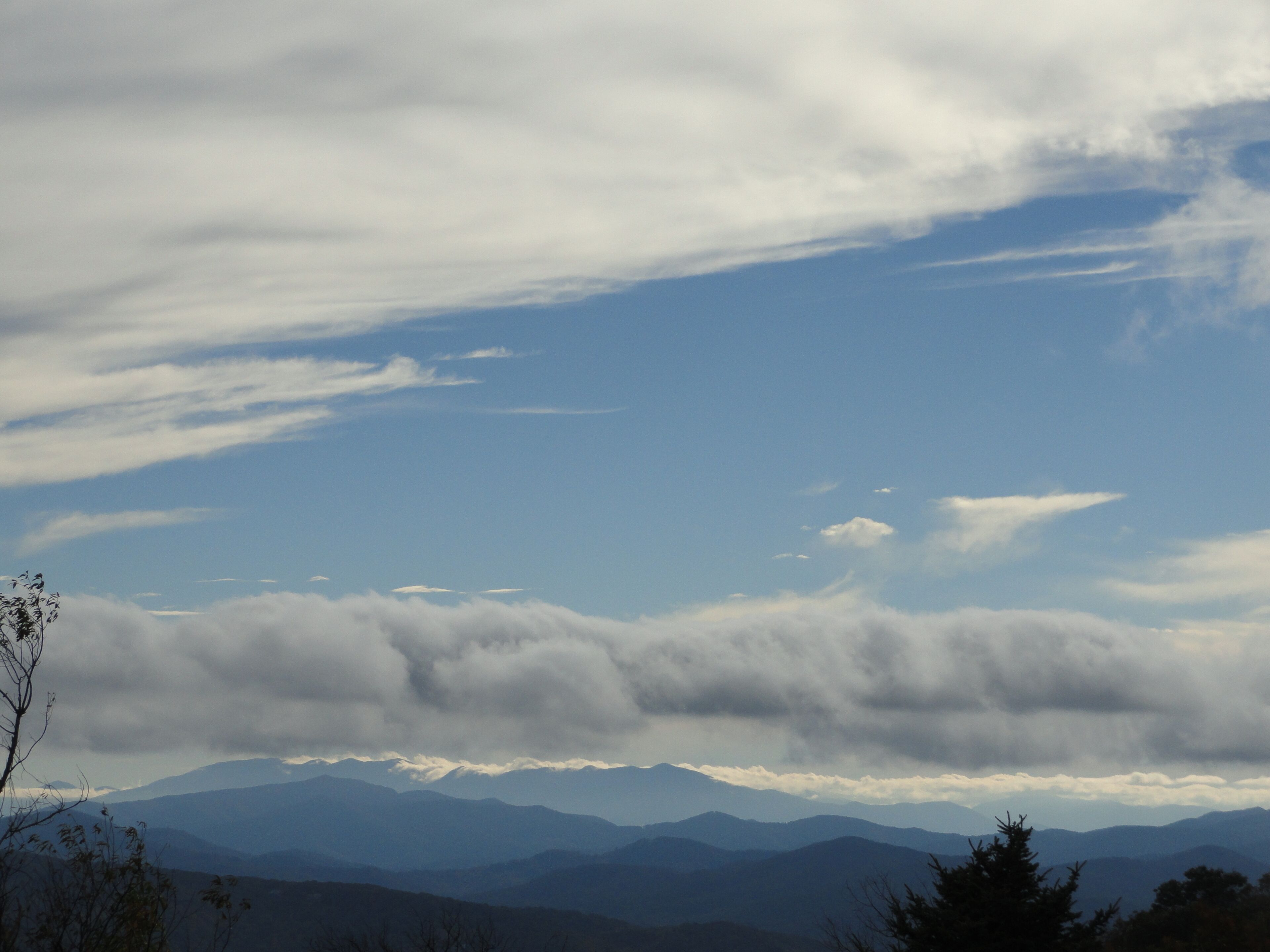 Un paysage de montagne avec un ciel dégagé et des nuages.