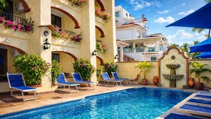 A swimming pool with lounge chairs, potted plants, and a fountain. - Lindo Mar Resort (Puerto Vallarta)
