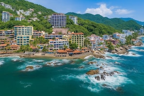 A coastal hotel with multiple buildings, a beach, and rocky coastline. - Lindo Mar Resort (Puerto Vallarta)