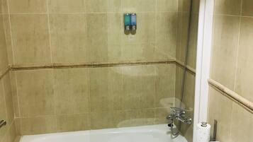 A bathroom with a bathtub, toilet, and a shower.