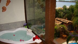 Un jacuzzi con vistas a una piscina y un edificio con techo de tejas.