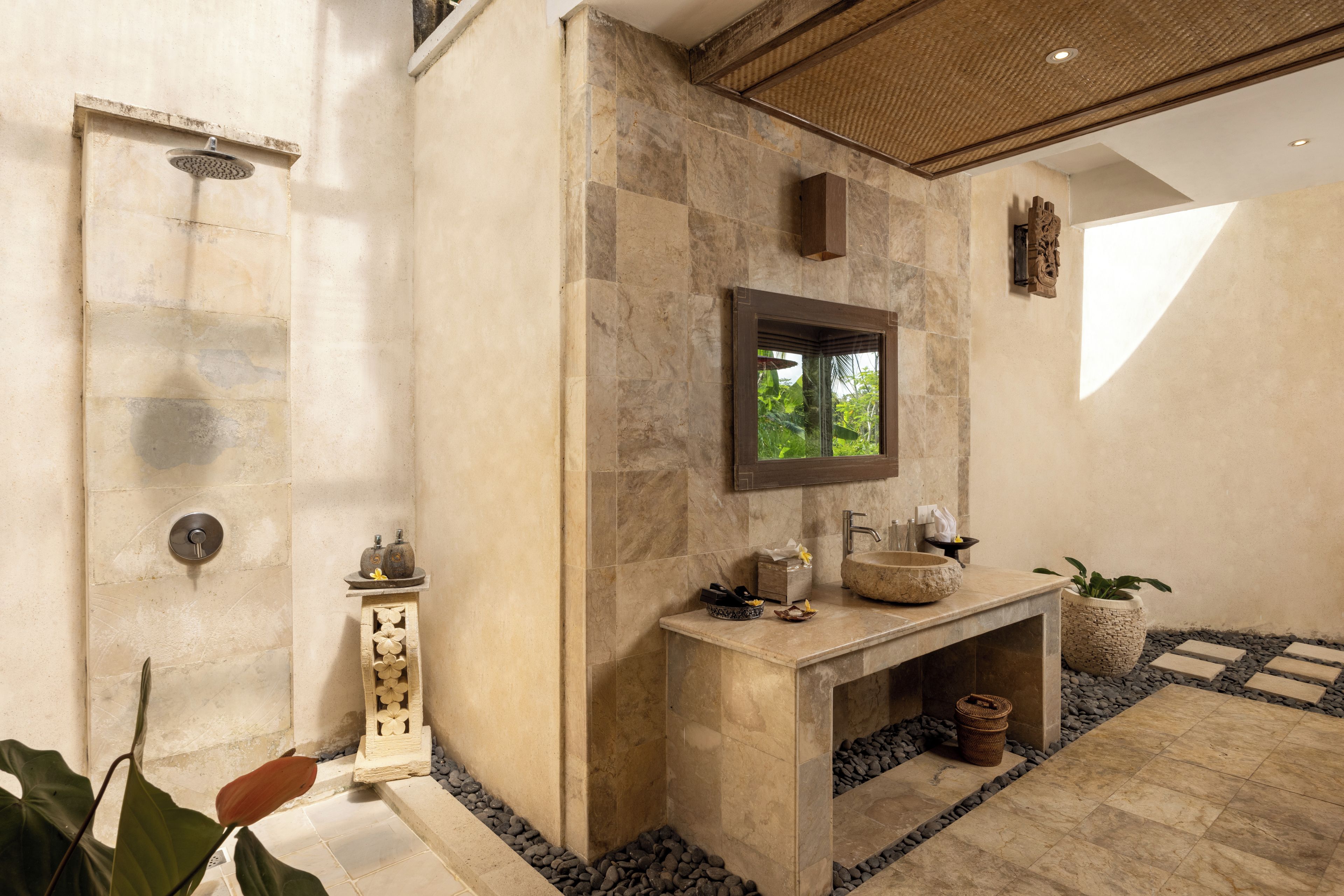 A bathroom with a shower, a sink with a mirror, and a window.