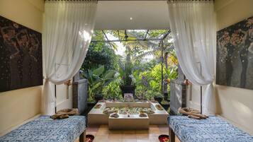 Enjoy a peaceful retreat with a garden view, two single beds, and a cozy seating area.