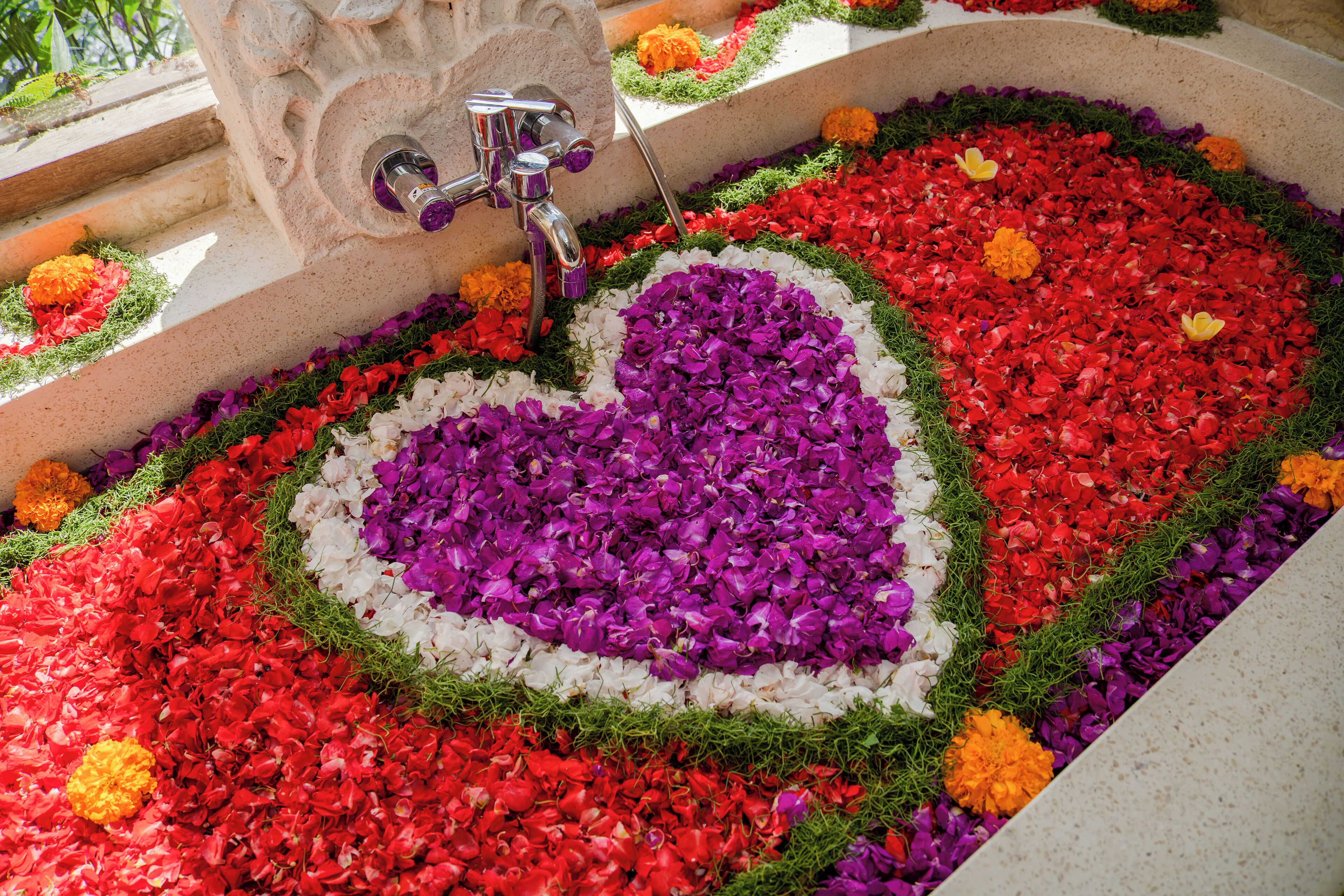 A heart-shaped flower arrangement in a bathtub.