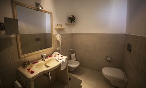 A bathroom with a sink, mirror, towel rack, bidet, and toilet. - Casale del Murgese (Fasano)