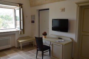 Ein kleines Zimmer mit Schreibtisch, Stuhl und Fernseher.