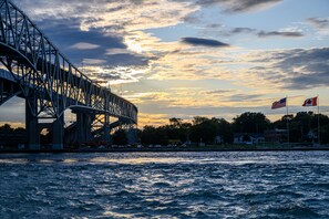 A bridge with two flags, one American and one Canadian, against a sunset sky. - Days Inn by Wyndham Sarnia Harbourfront (Sarnia)