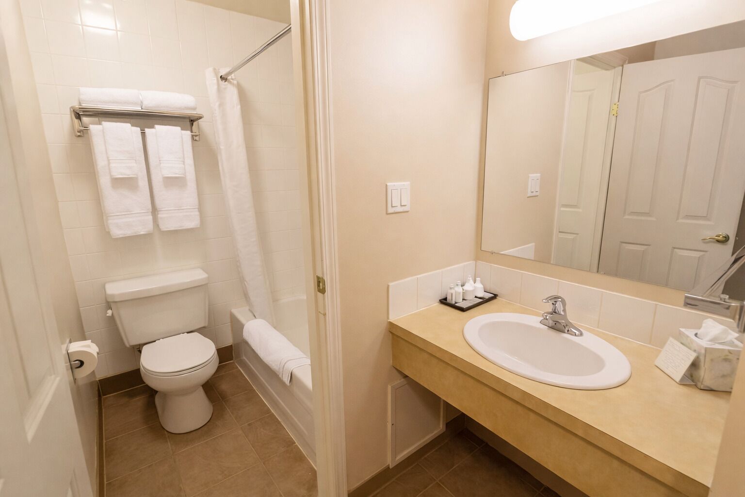 Een bad/douchecombinatie, een bubbelbad, handdoeken