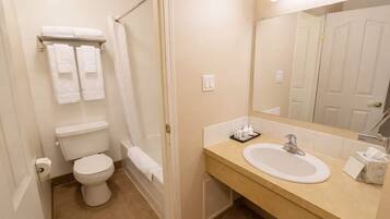 Een bad/douchecombinatie, een bubbelbad, handdoeken