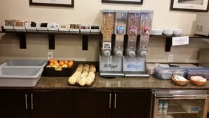 A breakfast bar with various food items and a coffee machine. - BCMInns Lac La Biche (Lac La Biche)