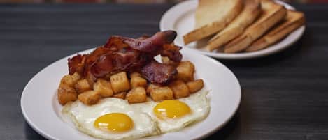 A plate of breakfast food including eggs, bacon, and hash browns.