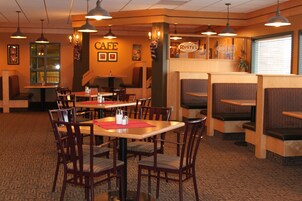 Interior de un restaurante con cabinas y mesas, un letrero que dice 'CAFE' y un letrero que dice 'Rusty's'.