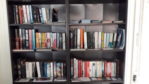 A bookshelf with various books, a certificate of excellence, and a 'Read Ad' sign. - Tropical Sunset Beach Apartment Hotel (Holetown)