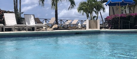 Piscine extérieure, parasols de plage, chaises longues