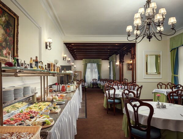 Un buffet proposant une variété de plats et une longue table entourée de chaises.