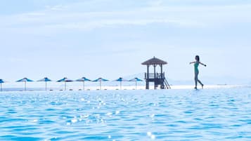 A beach with a lifeguard tower and umbrellas.