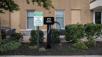 A charging station for electric cars with a sign indicating parking is only allowed while charging.