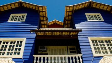 Ein blaues Gebäude mit Balkon und zwei Fenstern.