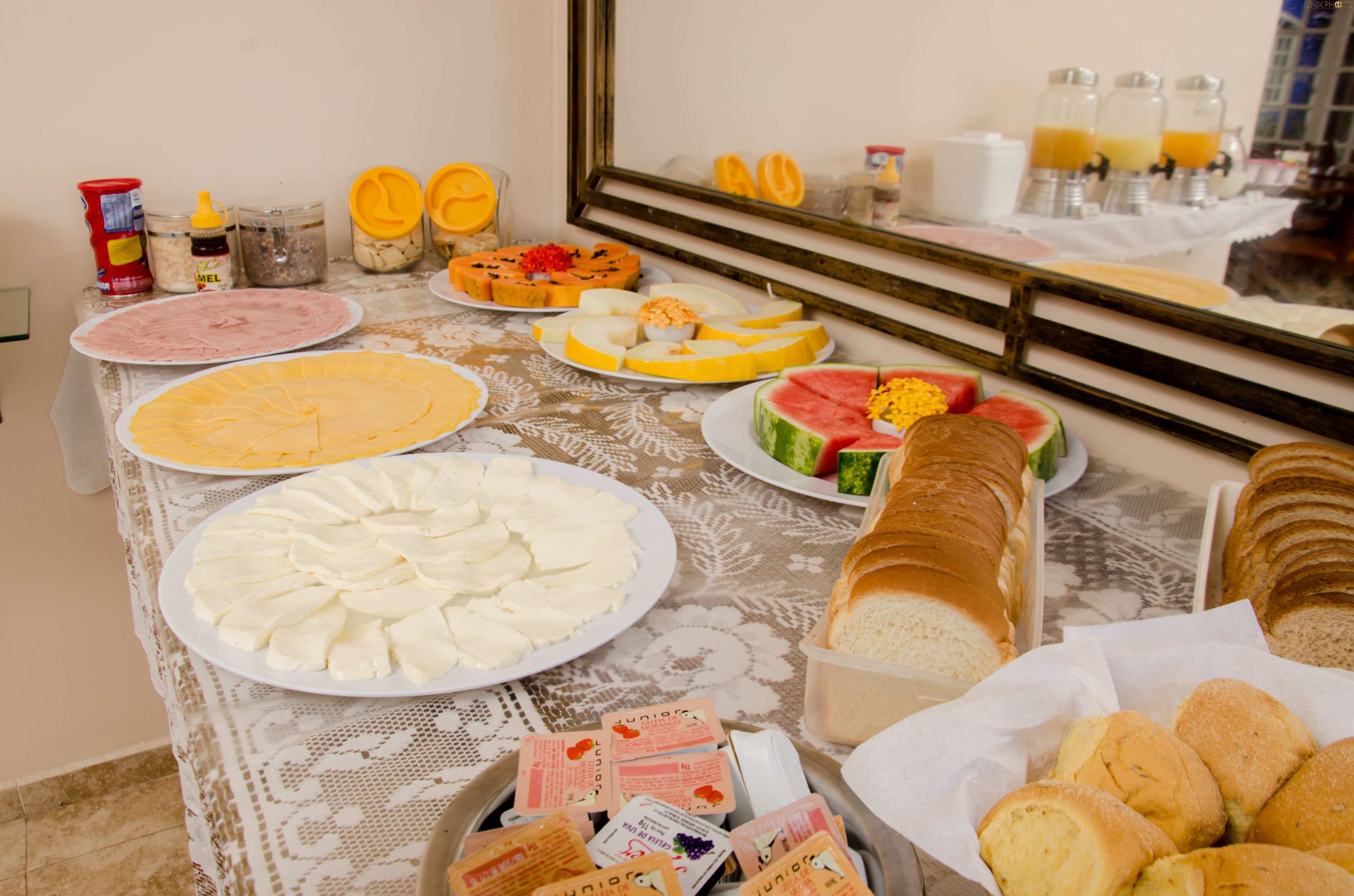 Een buffet met diverse gerechten, zoals brood, kaas, fruit en drankjes.