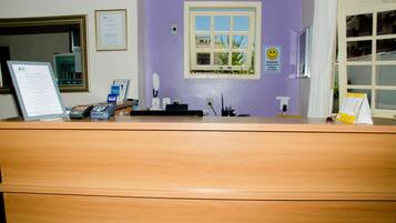 A reception desk with a computer, phone, and credit card reader.