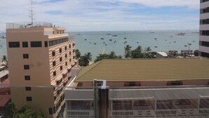 A coastal cityscape with a view of the sea and boats. - Inn House Hotel (Pattaya)