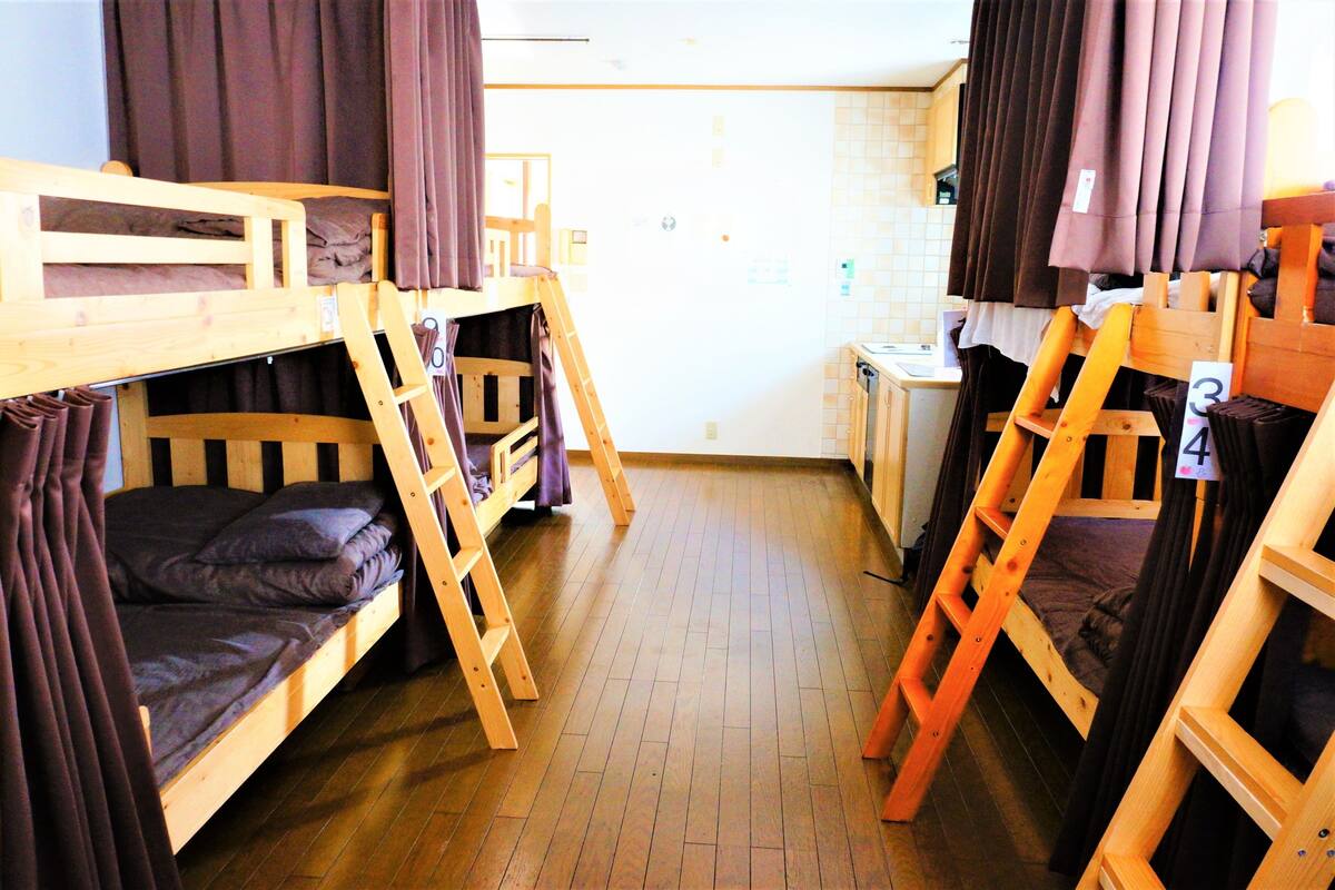 Un dormitorio con camas literas, muebles de madera y una pequeña kitchenette.