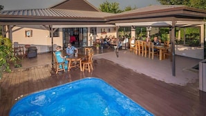 A covered outdoor area with a pool, wooden deck, and outdoor seating. - 7 Cascades Restaurant Bar & Lodges (Vacoas-Phoenix)