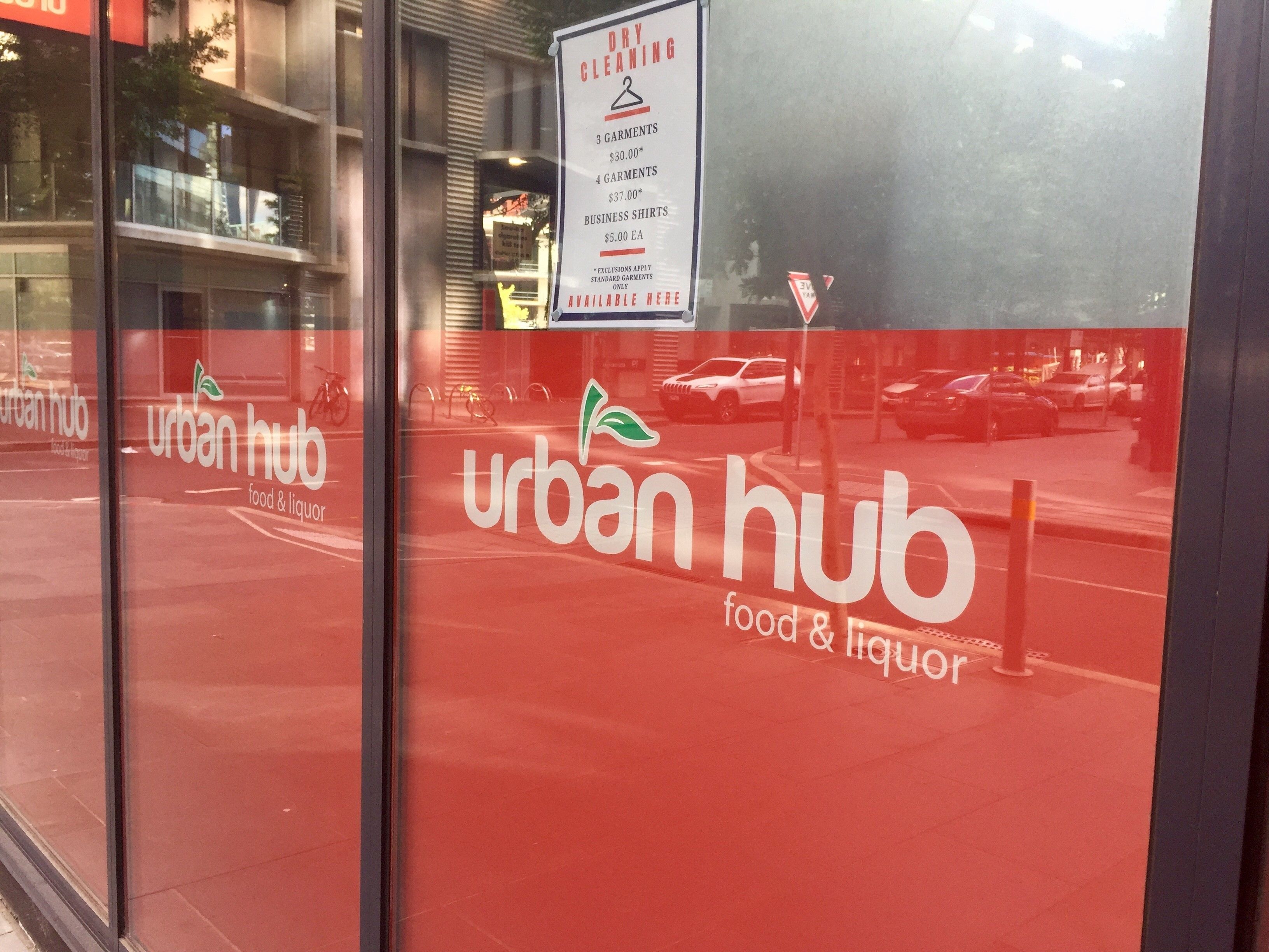 Ein Ladenfront mit roter Markise und dem Schriftzug "urban hub food & liquor" im Schaufenster.