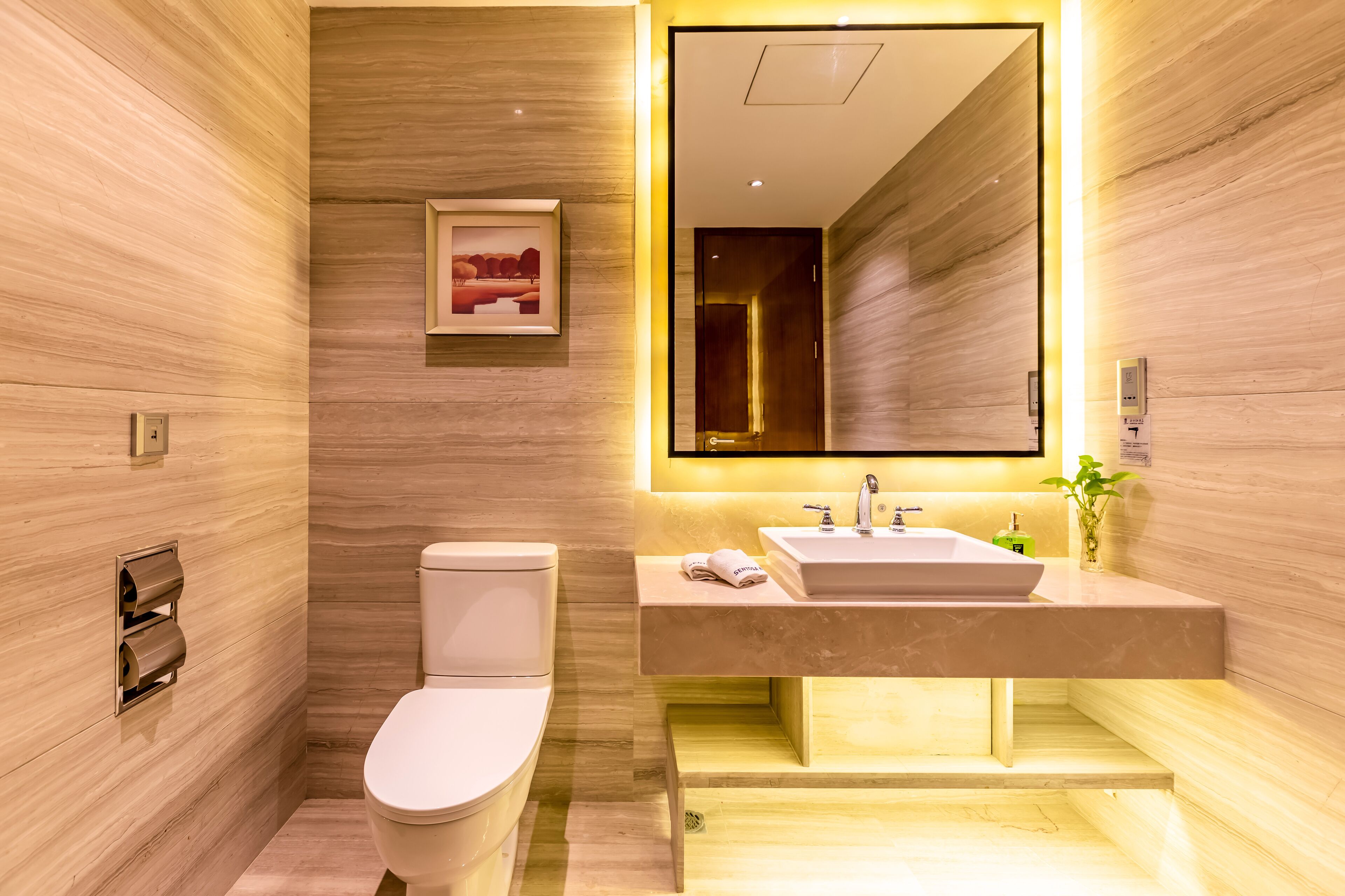 Une salle de bain moderne équipée de toilettes, d’un lavabo et d’un miroir.
