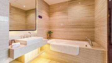 A modern bathroom with two sinks, a large bathtub, and a mirror.