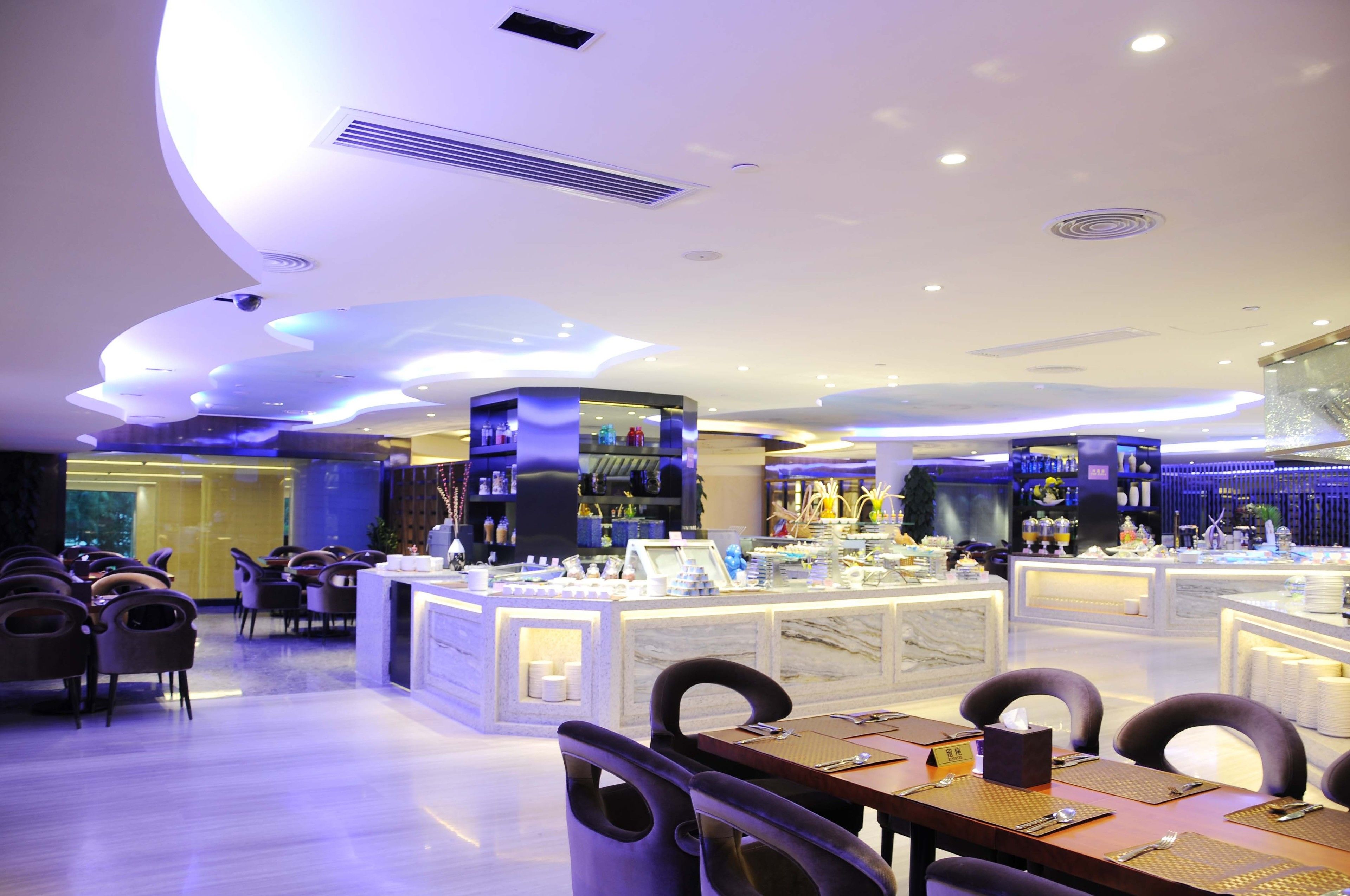Un moderno vestíbulo de hotel con una zona de bar central, arreglos de asientos y un mostrador de recepción de mármol.