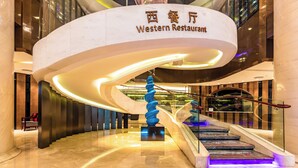 Ein modernes Interieur mit einer geschwungenen Treppe, einer blauen spiralförmigen Skulptur und einem Schild für 'Western Restaurant'.
