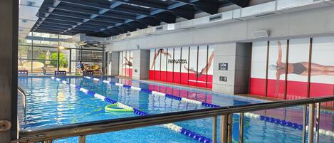Una piscina interior con separadores de carril y un puesto de socorrista.