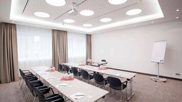 A conference room with a long table, chairs, a whiteboard, and a projector.
