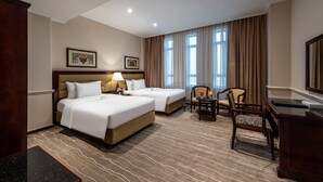 A hotel room with two beds, a desk, a chair, and a large window with curtains. - Boudl Abha (Abha)