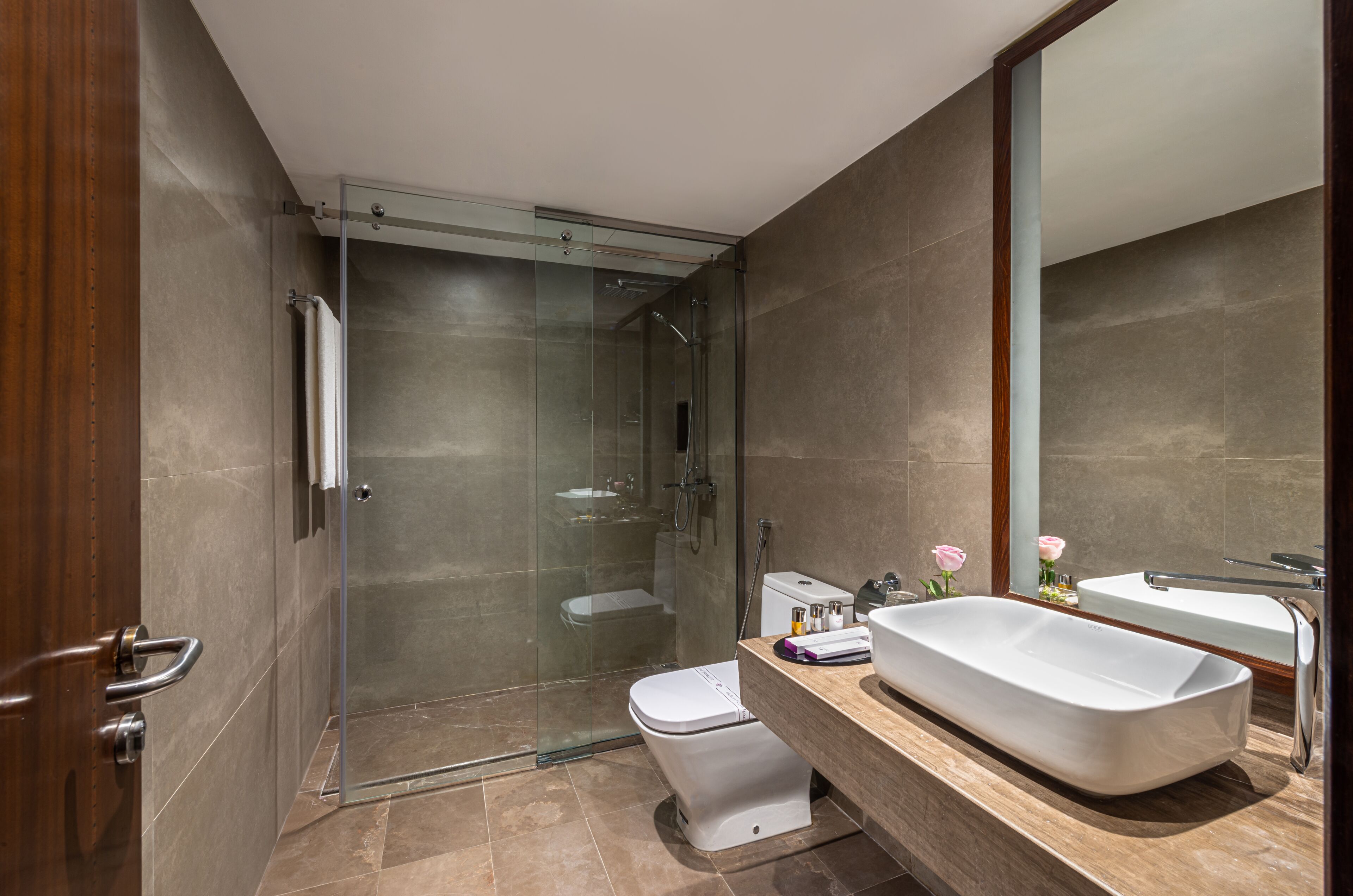 A modern bathroom with a glass-enclosed shower, a freestanding bathtub, and a toilet.