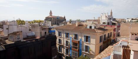 A cityscape with a prominent church, terracotta-roofed buildings, and a mix of residential and commercial structures.